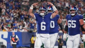 Jaxson_Dart_celebrating_touchdown_hands_up_Giants_blue_jersey_preseason_game_2025.jpg